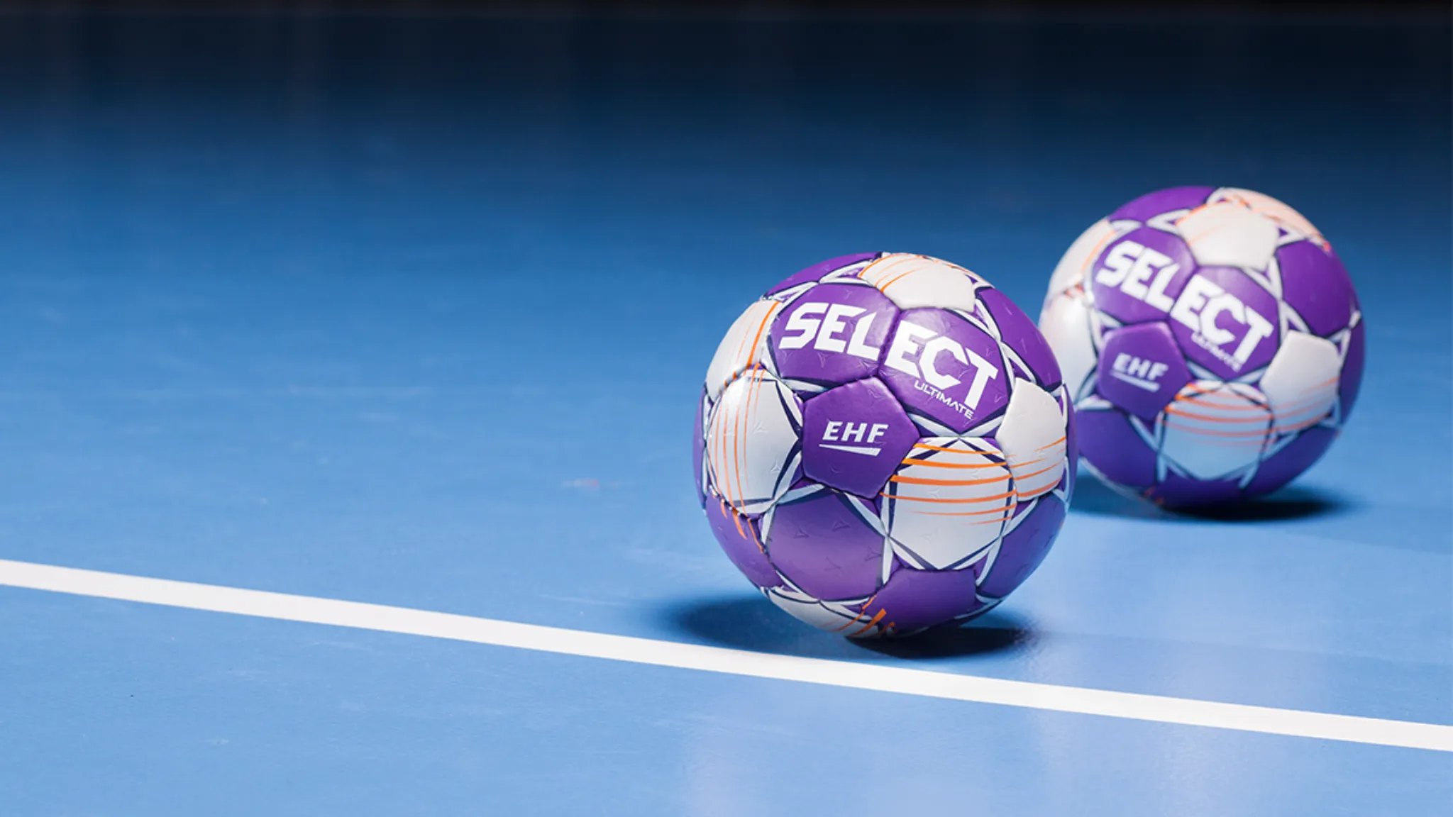 Select håndballer på blått hallgulv i ulike størrelser